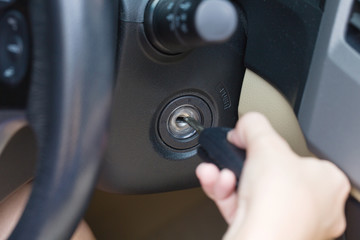 Female hand putting key in car.