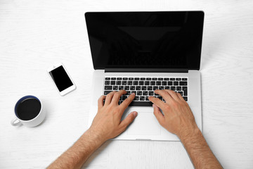 Man hand on laptop on table top view