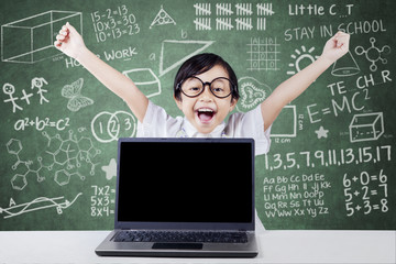 Child celebrate her success with laptop in class