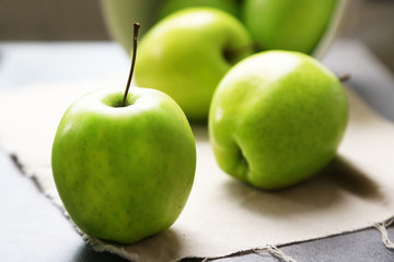 Green apples on wooden table with napkin, closeup