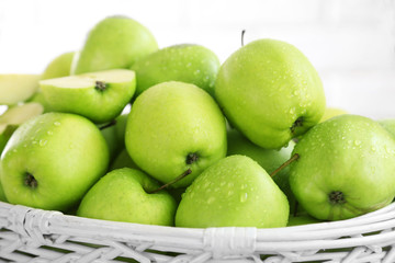 Green apples in wicker basket, closeup