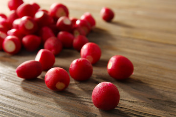 Heap of fresh radishes on wooden table close up background