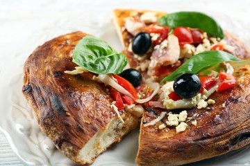 Pieces of homemade pizza on plate, on color table background