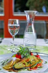 Ravioli mit Grillgemüse auf Trüffelölschaum mit Tomaten angerichtet Nahaufnahme