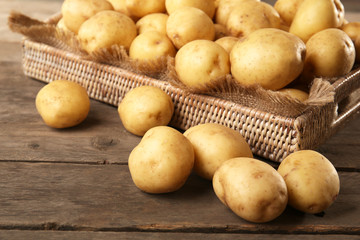 New potatoes in tray on wooden table, closeup