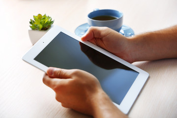Man with digital tablet on wooden table background