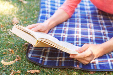 Young woman reading book in park 