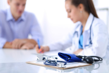 Obraz premium Doctor woman sitting with male patient at the desk