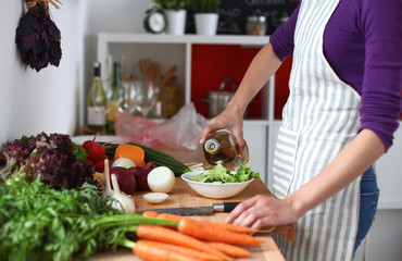 Young woman mixing fresh salad ,oil recharge