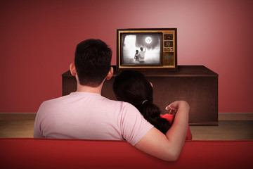 Young asian couple watching retro tv