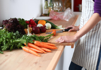 Young woman cutting vegetables in the kitchen