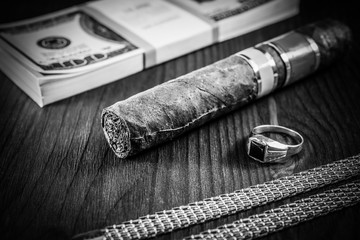 Expensive Cuban cigar and a pack of dollars with gold chain, gol © Georgii Shipin