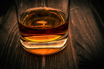 Glass of whiskey on a wooden table