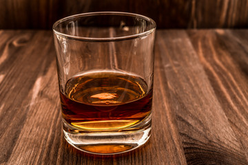 Glass of whiskey on a wooden table