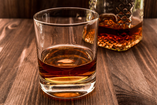 Decanter of whiskey and a glass on a wooden table