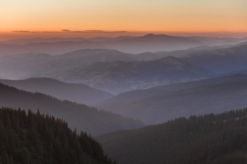 Distant mountain range and thin layer of clouds on the valleys