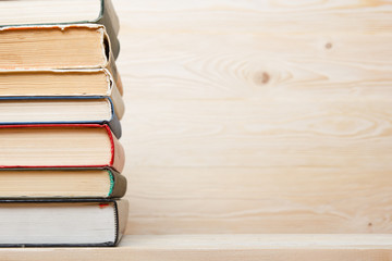 Stack of colorful books on wooden table. Back to school. Copy space