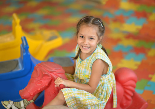 Little girl on  rocking horse.