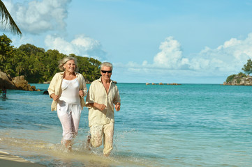 Elderly couple running  on beach