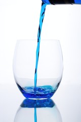 Blue drink is flowed into a glass