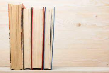 Stack of colorful books on wooden table. Back to school. Copy space