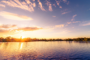 Sunset over the lake in the village. View from the coast