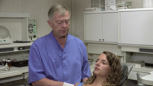 Dentist positions the chair of his patient