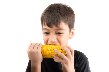 Little boy eating corn on white background