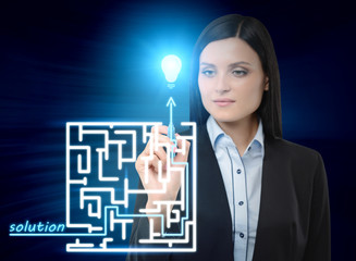Brunette business woman is drawing a labyrinth with solution on the glass screen. Modern hologram...