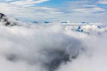 Above the clouds peaks on the horizon