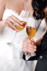 Hands of bride and groom with glasses of champagne