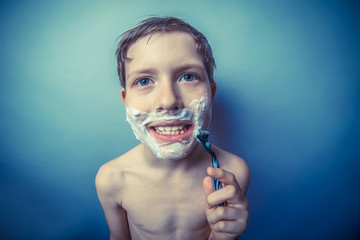 Boy teenager European appearance in brown hair foam on his face 
