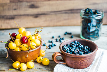 fresh raw blueberry, yellow cherry and mulberry  on gray wooden