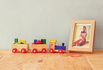 Wooden toy train next to photo frame with kid's photography