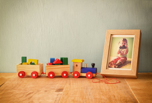 Wooden toy train next to photo frame with kid's photography