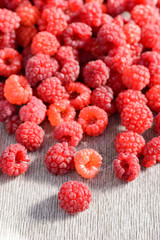 Ripe raspberries scattered on the table