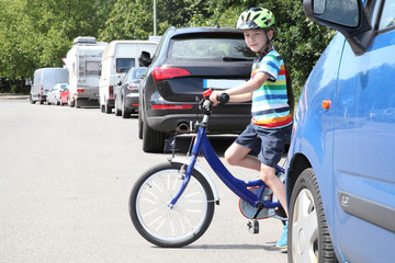 Junge mit Fahrrad am Straßenrand