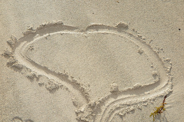 Heart drawn in the sand. Beach background. Top view
