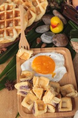 Sweet waffles and fresh milk with jam and egg heart.