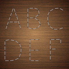 Vector modern staples alphabet on wooden 