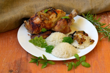 Roasted chicken with herbs and rice on wooden background