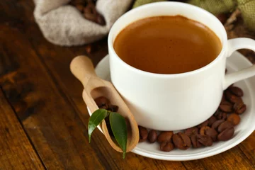 Fotobehang Cup of coffee with beans on table close up © Africa Studio