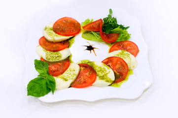 Caprese salad with mozzarella cheese, tomatoes and green lettuce