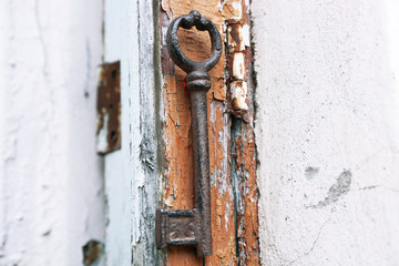 Old key on wooden antique door close-up