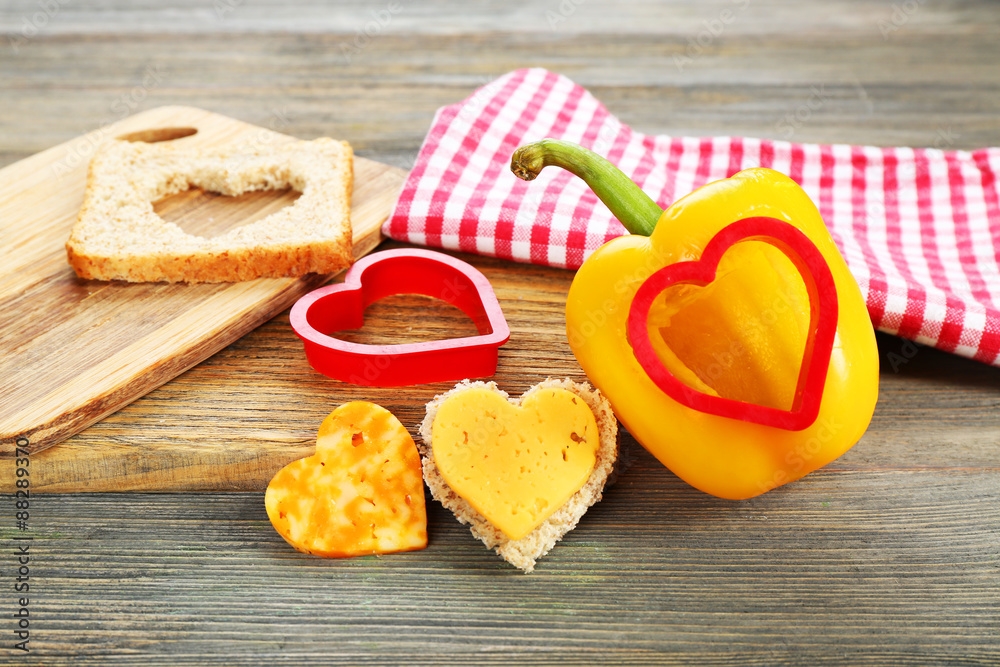 Poster salad pepper with cut in shape of heart and cheese on table close up