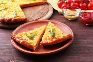 Slices of tasty cheese pizza with arugula and vegetables on table close up