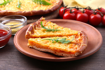 Slices of tasty cheese pizza with arugula and vegetables on table close up