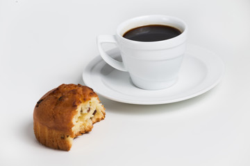 Half-eaten muffin with coffee cup on a white background