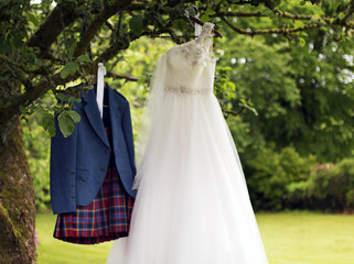 Kilt and wedding dress hanging on a tree
