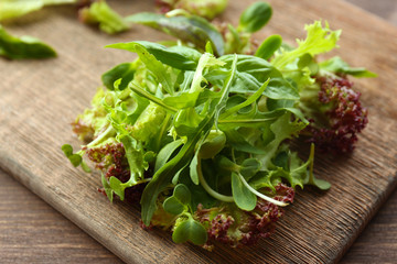 Plate of fresh mixed green salad on wooden table close up